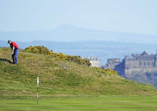 Edinburgh Castle provides a stunning backdrop as RICS' Brian Tait chips at the 17th at the Braids in the first round of the 119th Dispatch Trophy: Picture: Neil Hanna
