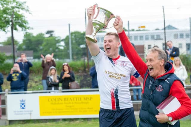 Departing Civil Service Strollers manager Alex Cunningham lifts the South Challenge Cup with captain Stephen Froude. Pic: Ian Georgeson
