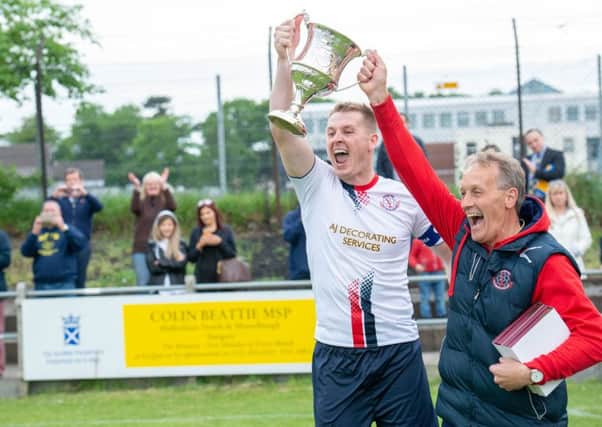 Departing Civil Service Strollers manager Alex Cunningham lifts the South Challenge Cup with captain Stephen Froude. Pic: Ian Georgeson