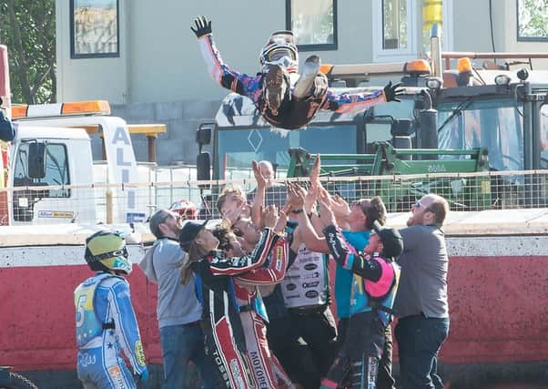 Ricky Wells is hoisted aloft by riders and mechanics in celebration of his 15-point maximum. Pic: Ron MacNeill
