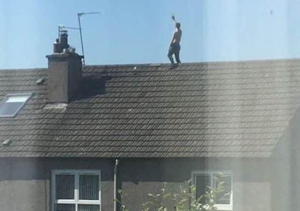 The man was seen walking up and down the rooftop