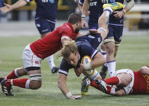 Scotland's David Denton is tackled by Canada's Luke Campbell and Nick Blevins. Pic: Jason Franson/The Canadian Press via AP