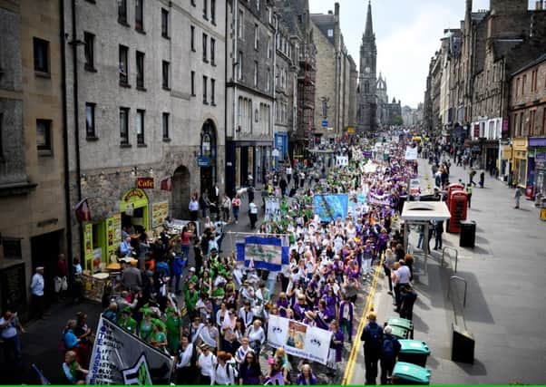 Women hold up banners as they march down the Royal Mile during Processions 2018. Picture: Getty