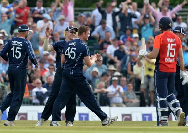 Alasdair Evans of Scotland is congratulated by his team mates after tacking the wicket of David Willey of England