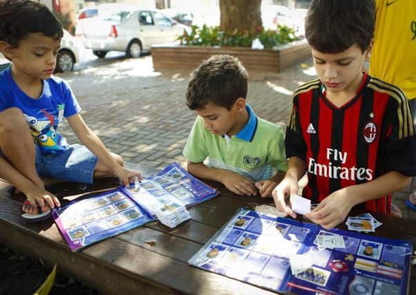 Kids checking their sticker albums in Brazil