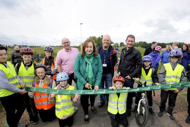 Councillor Lesley Macinnes and Sustrans Scotland national director John Lauder (in pink shirt) with youngsters from Danderhall Primary Scholl, Midlothian, opening the new cycle path. Photo by Colin Hattersley