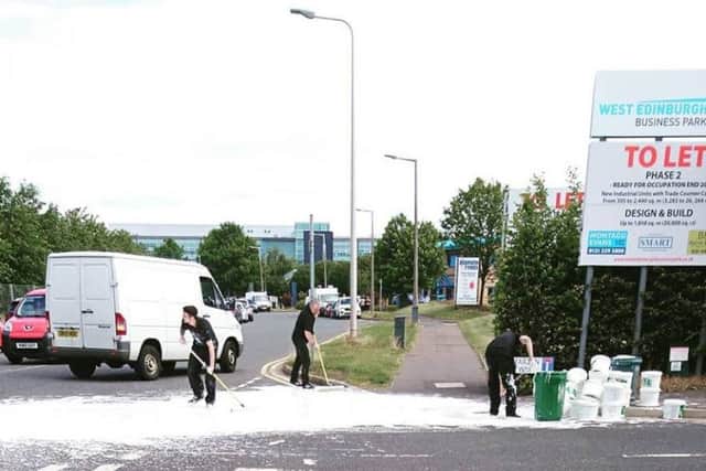 Workmen attempt to clear up the spillage at South Gyle Crescent. Picture: Andrew Clark