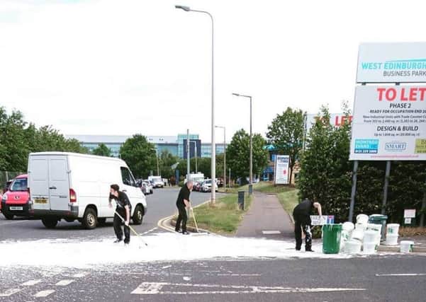 Workmen attempt to clear up the spillage at South Gyle Crescent. Picture: Andrew Clark