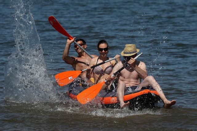 Siblings Zoltan, Anna and Peter take advantage of the hot weather sweeping across the country whilst kayaking at Portobello beach. Picture; PA