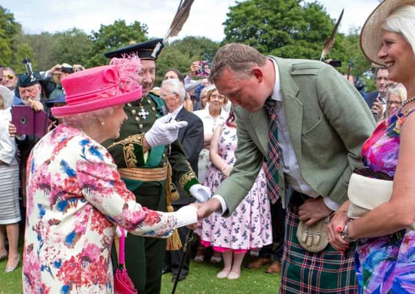 Britain's Queen Elizabeth II meets former Scotland ruby union player Doddie Weir (R) as she hosts the annual garden party at the Palace of Holyroodhouse in Edinburgh on July 4, 2018. Picture; Jane Barlow