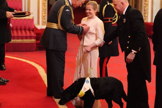 Lora Fachie, with her guide dog Tai, is made an MBE (Member of the Order of the British Empire) by the Prince of Wales at Buckingham Palace. Picture: Yui Mok/PA Wire