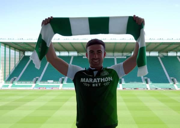 Stevie Mallan holds a Hibs scarf aloft after completing his move to Easter Road. Picture: Hibs TV