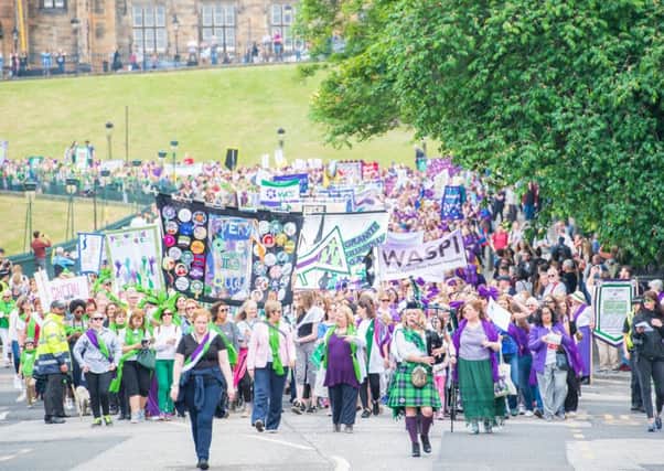 Protesters march in Suffragette colours in Edinburgh to mark the anniversary of women getting the vote in the UK