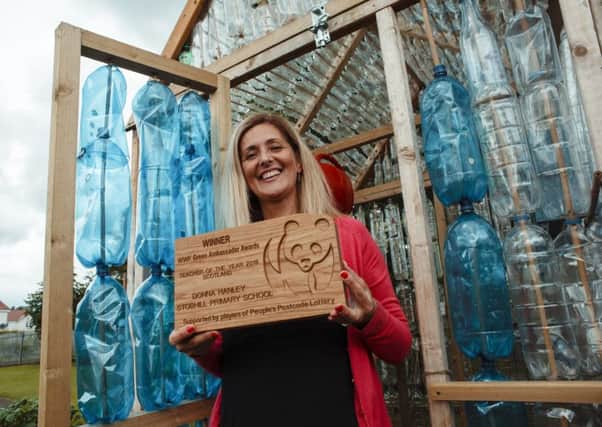 Donna Hanley, a teacher at Stobhill Primary in Gorebridge, with her award, pictured at the bottle greenhouse.