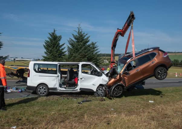 A car is removed from the A96 between Huntly and Keith in Moray where a five people have died and five more were injured after a crash between a minibus and a car. Picture; PA