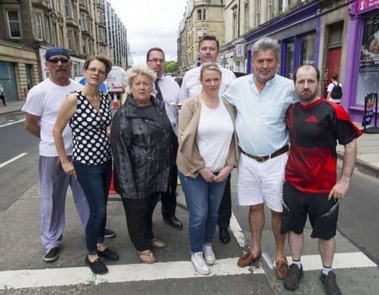 Spokesperson Kim McBride (third left front row ) pictured with shop keepers and owners of retail outlets in Haymarket Terrace after their premises were flooded on Saturday because of blocked drains despite that road have been dug up and new drains installed. Picture Ian Rutherford