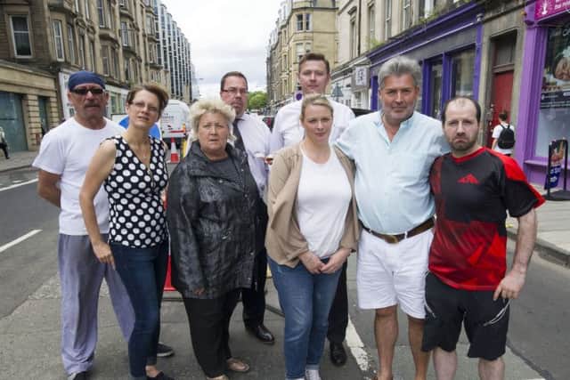 Spokesperson Kim McBride (third left front row ) pictured with shop keepers and owners of retail outlets in Haymarket Terrace after their premises were flooded on Saturday because of blocked drains despite that road have been dug up and new drains installed. Picture Ian Rutherford