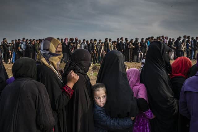 Civilians who have remained in Mosul line up for an aid distribution in the Mamun neighbourhood of the city. Picture: Ivor Prickett/The New York Times