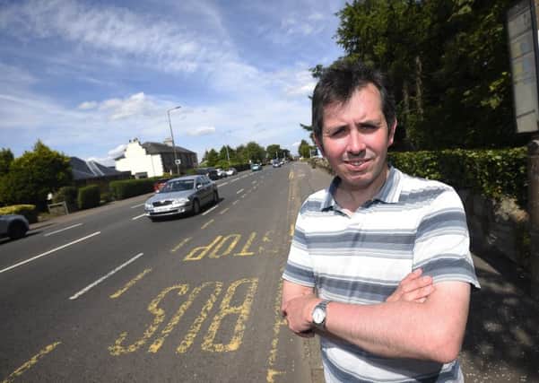 Councillor Jason Rust at the section of road on Buckstone Terrace where the council were given Â£64,000 by the builders of 300 new homes to install a pedestrian crossing in December 2013 but it still hasn't been installed.