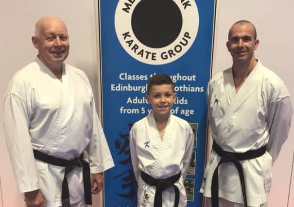 Bailey (9) is the latest member of the Adams family to hold a black belt in karate and is pictured alongside proud dad Steven and grandfather Hamish