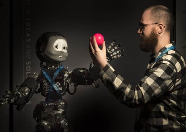 Phd student Eli Sheppard from Heriot Watt Edinburgh Centre for Robotoics plays with Nikita, a childlike humanoid robot that has been in development for more than 10 years.