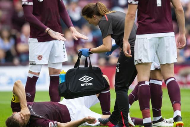 Hearts captain Christophe Berra lies in agony on the turf after tearing his hamstring against Celtic. The centre-half will not be seen again this year. Pic: SNS