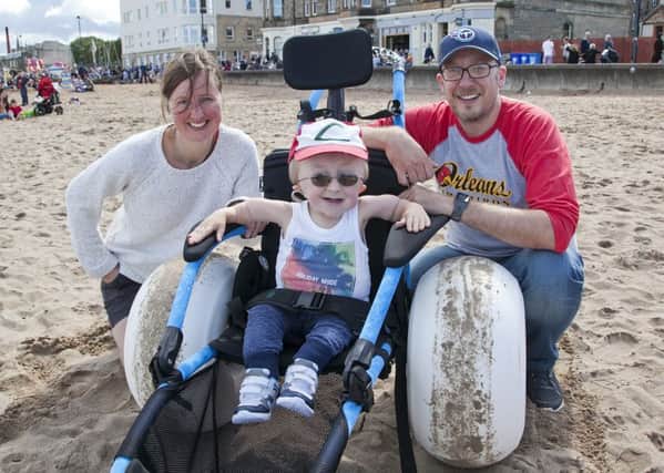 Alison and Craig Brown with Ethan, nine, in a beach wheelchair at Portobello. Picture: Alistair Linford