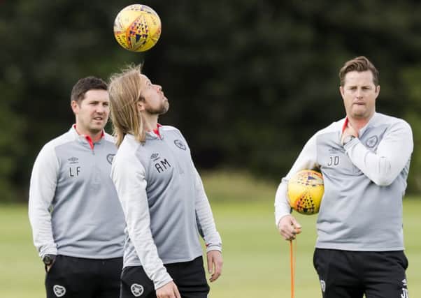 Coaches Liam Fox, left, and Jon Daly watch as Austin MacPhee shows his skills on the training pitch