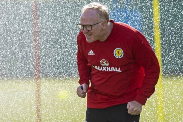 Scotland manager Alex McLeish is caught by a nearby sprinkler during training
