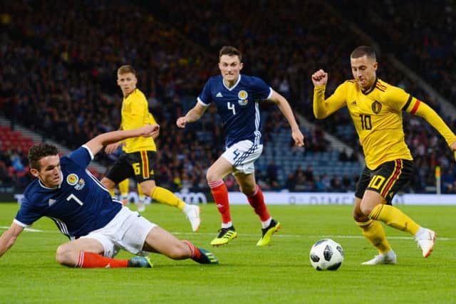 John Souttar, centre, tries to get back as John McGinn, left, faces Eden Hazard