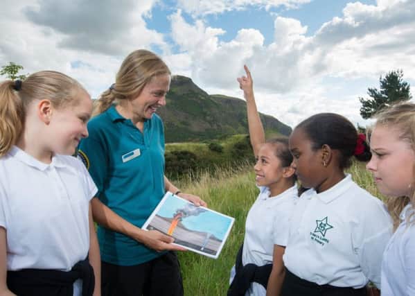 Holyrood Park Assistant Ranger Melissa Viguier giving a talk and taking a school group on a tour around Holyrood park covering subjects on volcanoes, geology and wildlife.