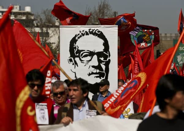 Demonstrators carry a banner of Chile's late President Salvador Allende, days ahead of the 45th anniversary of the 1973 military coup that toppled him (Picture: Esteban Felix/AP)