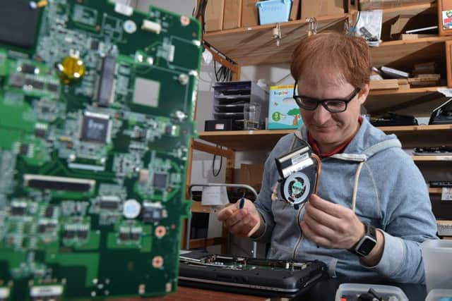Mario Di Filippo repairs a laptop for the Syrian refugee programme at Edinburgh Remakery. Picture: Jon Savage