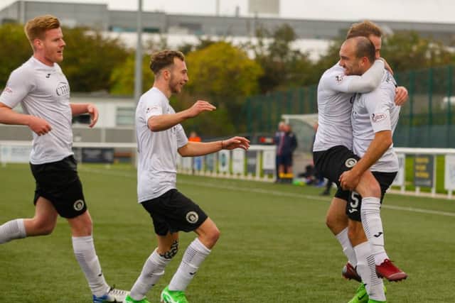 The Edinburgh City players rush to congratulate Conrad Balatoni after he headed the only goal. Scott Louden