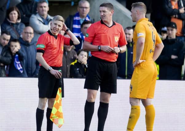 Assistant referee Calum Spence feels the back of his head after being hit by a coin. Picture: SNS Group