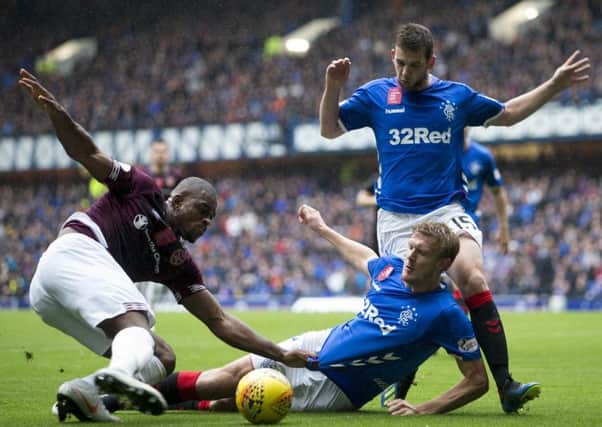 Uche Ikpeazu (left) and Joe Worrall battle for the ball during the  Scottish Premiership match at Ibrox. Picture: PA
