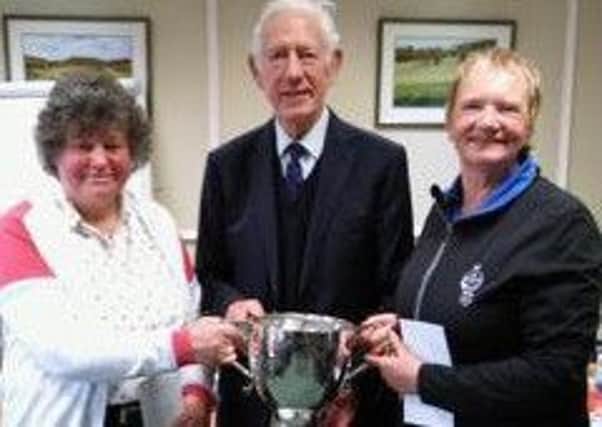 Gibson Cup winners Mary Stark and Anne Brownie receive the trophy from Clifford Hastings