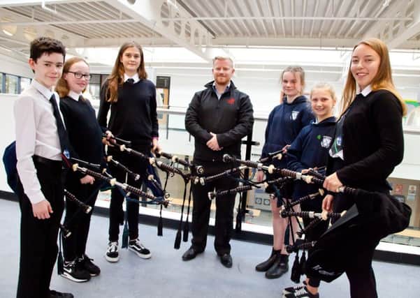 Pupils at Tynecastle High School and Craiglockhart Primary School receive their new pipes, loaned by the Scottish Schools Pipes and Drums Trust. Pictured from left to right: Caleb Robson, Caitlin Mackay, Rebecca Watson, Craig Munro of the Red Hot Chilli Pipers and director of Wallace Bagpipes, Eilidh Brown, Alina Mackenzie, Maya Watson.