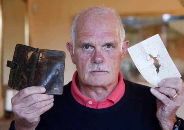 Keith Miller with letters and wallet showing the bullet hole that belonged to his grandad who was killed in WW1. Picture: Alistair Linford