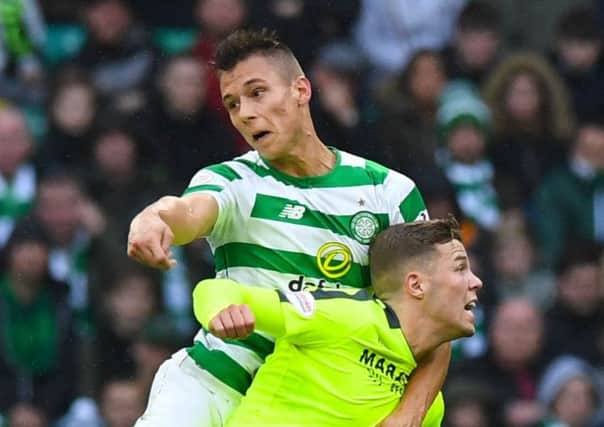 Celtic's Filip Benkovic heads clear under pressure from Hibs' Florian Kamberi. Pic: SNS