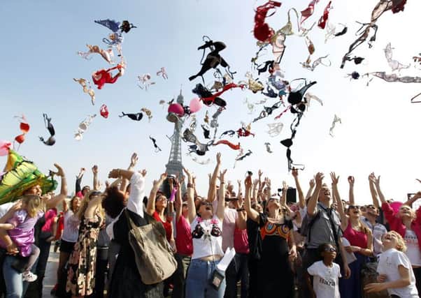 Campaigners in Paris hurl their bras into the air as part of a campaign to raise awareness of breast cancer. Picture: AFP/Getty