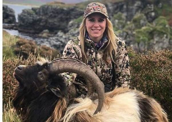 TV presenter Larysa Switlyk smiles for the camera as poses with one of the goats she shot
