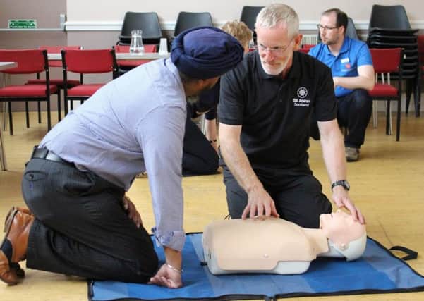 A St John Scotland volunteer demonstates CPR.