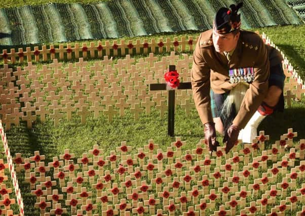 Captain Gary Rattray - 41 from Coatbridge, from 2 SCOTS the Royal Regiment of Scotland places a cross in the Poppy Garden. Police are investigating after a vandal attack over the weekend