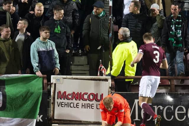 Hearts goalkeeper Zdnek Zlamal lies on the ground after an altercation with a Hibernian fan
