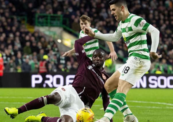 Clevid Dikamona slides in to tackle Celtics Tom Rogic. The defender has grasped his chance since injuries to Christophe Berra and John Souttar
