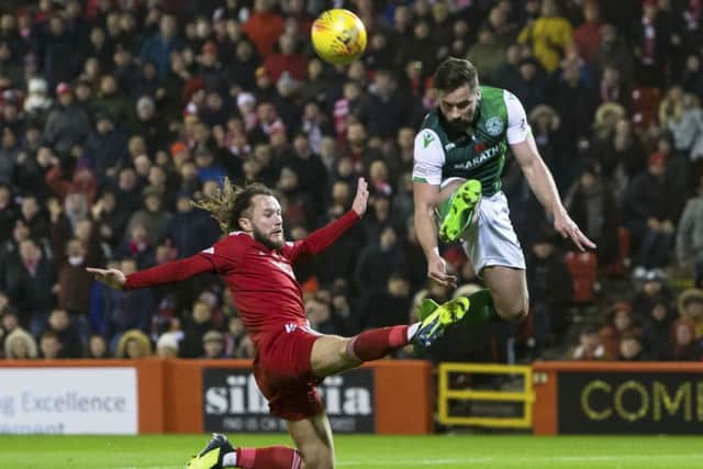 Darren McGregor hurdles over the outstretched leg of Aberdeens Stevie May at Pittodrie
