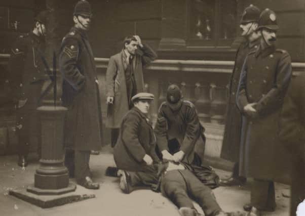 David Kirkwood (before he became MP) on the ground after being batoned by police, while Willie Gallacher stands by after being arrested.
 Pic: from exhibition