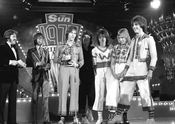 Alan Longmuir accepts award as Top Pop Band for 1975 with the rest of the Bay City Rollers.