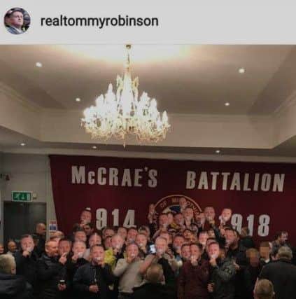 The photo shared by Tommy Robinson on Instagram showing a group wearing masks in front of a McCrae's Battalion Hearts flag. Picture: Instagram/Tommy Robinson